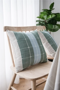Detail of Nordic style patchwork plaid pillow featuring striped patterns and linen texture