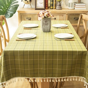 Close-up of green plaid tablecloth with cotton-linen texture and elegant tassel edges