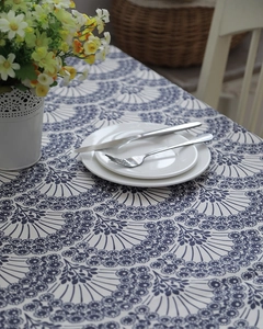 Detailed view of leaf pattern cotton tablecloth with elegant dinnerware and floral decor