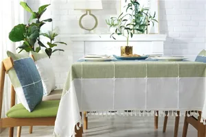 Close-up of waterproof plaid tablecloth with elegant embroidery and white tassels