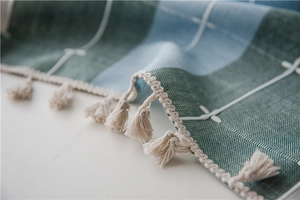 Close-up of Nordic striped table runner with dark green texture and white tassels