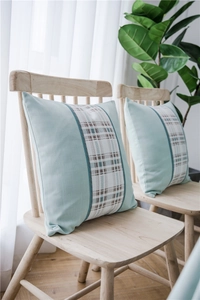 Close-up of light blue linen cushion cover featuring decorative woven geometric patterns