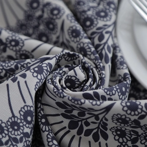 Macro shot of thick cotton canvas tablecloth featuring blue floral leaf patterns