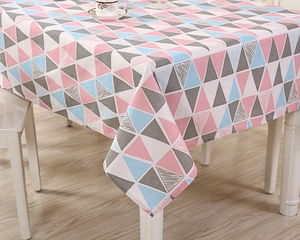 Detail of fabric tablecloth featuring modern geometric triangle patterns in soft pastel colors