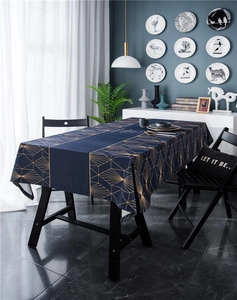 Detail of dark blue velvet tablecloth featuring luxurious gold geometric sunburst patterns