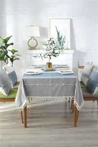 Close-up of geometric embroidered linen tablecloth with delicate white cotton tassels