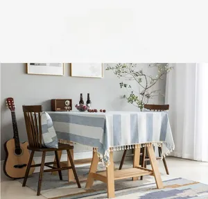 Close-up of blue and white striped cotton linen tablecloth with elegant white fringe