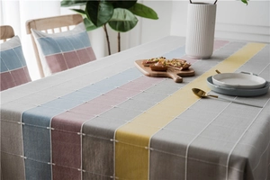 Detail of waterproof linen-like table runner with Nordic grid pattern and colorful stripes