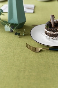Close-up of grass green waterproof tablecloth with weave texture and elegant floral lace