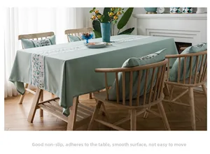 Close-up of waterproof faux linen tablecloth with colorful abstract pattern and matching cushions