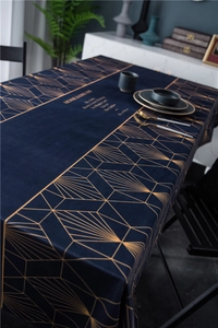 Close-up of luxury navy velvet tablecloth with gold geometric patterns and lettering