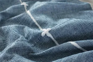 Close-up of blue cotton linen tablecloth with white grid embroidery and textured weave