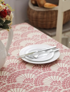Close-up of thick cotton canvas tablecloth with red floral pattern and cutlery setup