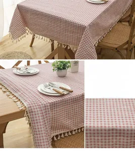 Detail of pink plaid tablecloth fabric with elegant white tassels and thick texture