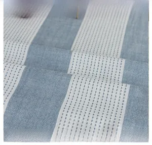 Close-up of blue and white striped cotton linen fabric showing texture and drape