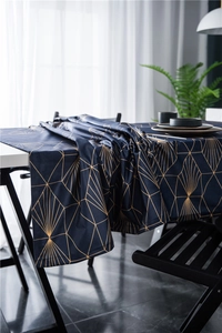 Detail showing deep blue velvet table runner with gold geometric lines and fine edges