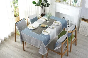 Detail of blue and gray checkered tablecloth with white lace edges and matching chair cushions