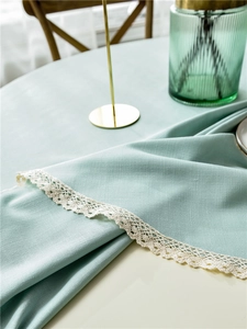 Detail of mint green linen table cloth showing exquisite white lace edges and texture