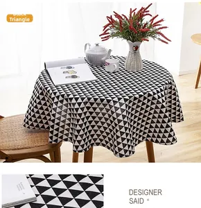 Detail of round linen-blend tablecloth featuring black geometric triangle print and tassels