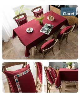 Detail of wine red tablecloth and cushions with geometric embroidered lace trim