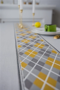 Close-up of waterproof faux linen table runner with yellow and grey diamond patterns