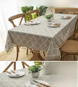 Close-up of modern grey-green tablecloth with diamond lattice and white fringe