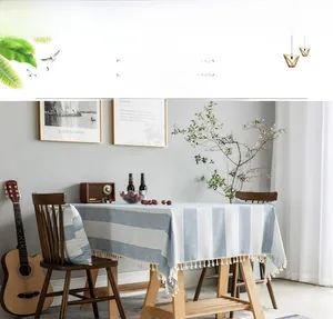 Close-up of blue and white striped linen tablecloth featuring decorative white fringe