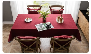 Close-up of deep red tablecloth with sequin trim and thick cotton blend texture