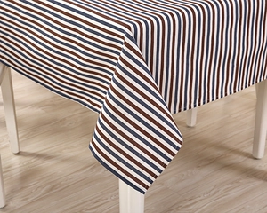 Close-up detail of the striped fabric tablecloth edge with neat stitching and heavy drape