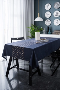 Detail view of velvet tablecloth showing gold geometric diamond patterns and deep blue fabric