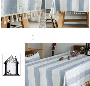 Close-up of blue and white striped cotton linen tablecloth with cream tassel trim