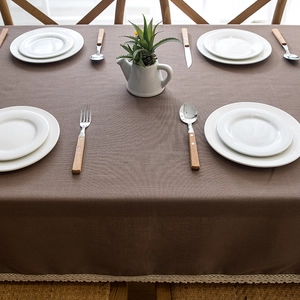 Detail of dark brown tablecloth with elegant beige lace trim and linen texture