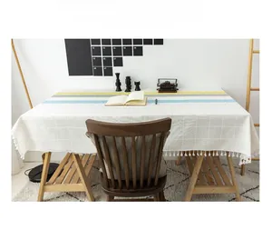 Close-up of Nordic striped tablecloth with fringe detail and woven grid texture surface