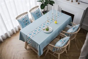 Close-up of waterproof faux linen table runner with blue geometric diamond pattern