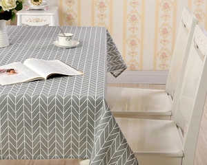 Detailaufnahme der grau-weißen Tischdecke mit Fischgrätenmuster und Stoffstruktur