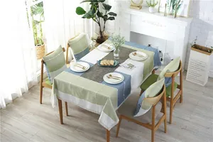 Close-up of green and blue checkered linen tablecloth with delicate white lace edges