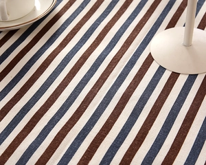 Close-up of woven fabric texture with brown, navy, and beige stripes on a tablecloth