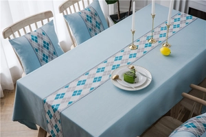 Close-up of waterproof polyester faux linen table runner with blue and grey argyle patterns