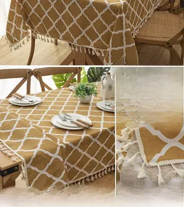 Detail of yellow diamond pattern tablecloth with elegant white tassels on mixed fabric