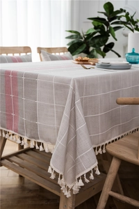 Detail view of linen texture table runner with pink stripes and cream fringe tassels