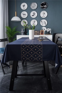 Close-up of luxury dark blue velvet tablecloth with golden geometric diamond patterns