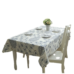 Modern cotton canvas tablecloth featuring blue pineapple and leaf patterns on a white table