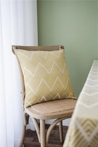 Close-up of mustard yellow and white geometric wavy woven fabric on a stylish throw pillow