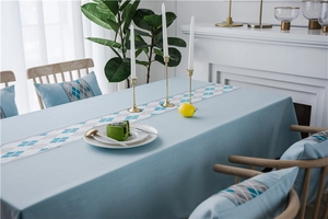 Detail of waterproof geometric faux linen table runner and matching chair pads in light blue