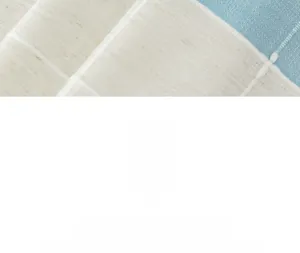 Detailed close-up of textured woven tablecloth featuring blue and beige geometric patterns