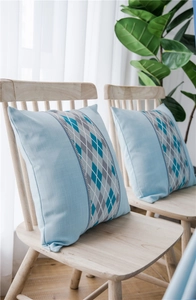 Detailed texture of waterproof blue cushion cover with argyle pattern on a wooden chair