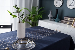 Close-up of velvet tablecloth featuring gold geometric diamond patterns and fine texture