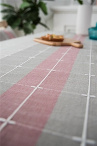 Close-up of geometric striped table runner with cotton linen texture and fringe detail