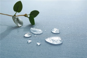Detail of waterproof light blue fabric texture showing water droplets on tablecloth surface