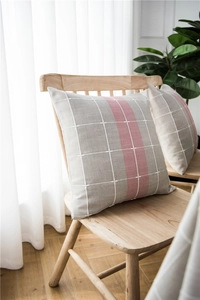 Close-up of minimalist grey and pink striped linen cushion on a wooden chair